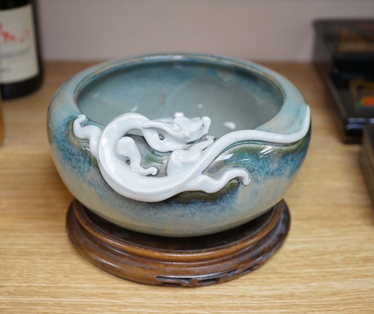 A Japanese Sumidagawa ware ‘dragon’ bowl, Meiji period, signed Ishiguro Koko, wood stand. Condition - scratching and crazing to the glaze on the interior otherwise good.